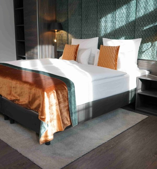 Dreibettzimmer Premium im Boutique Hotel Germania in München mit hochwerteigen Samtbettbezügen in orange und grün