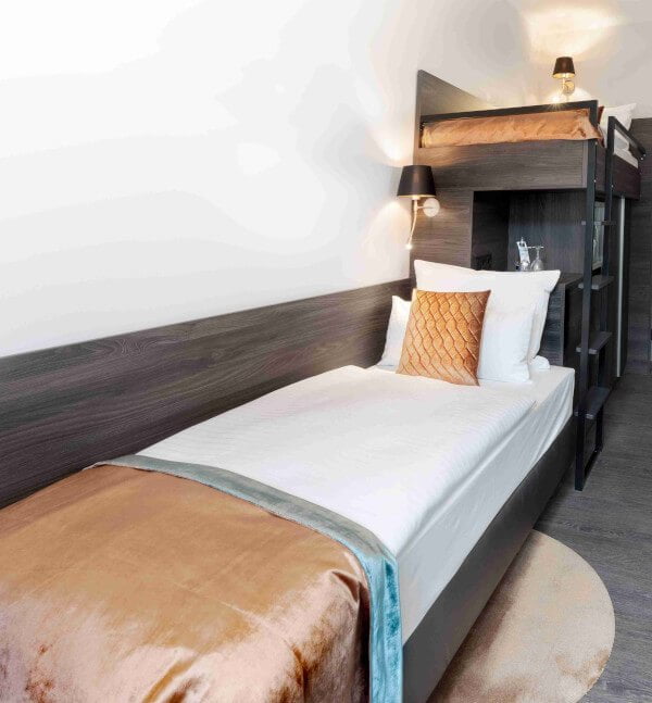 Duplex Zimmer Premium in München mit dunklem Holz und Samtbettbezügen